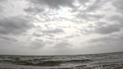 Cloudy Sky with Sun Rays Through Over Stormy Sea Waves time lapse Stock Footage 341699184