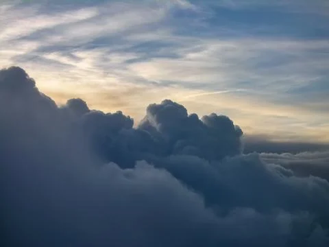 A cloudy sky with a sunset in the background, as seen from an airplane. Stock Photos
