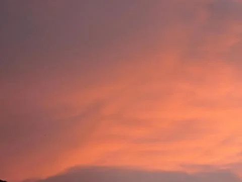 A cloudy sky at sunset with soft pink, orange, and purple hues. 库存照片