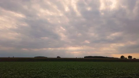 Cloudy sky at sunset with sun rays on field Stock Footage 204724672
