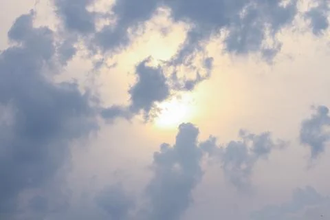 Cloudy sky at sunset with the sun shining through. Stock Photos