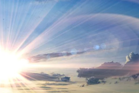 Cloudy sky at sunset time, yellow sun rays or beams go through the cloud Stock Photos