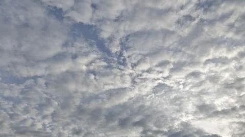 Cloudy Sky with Swirling Patterns and Sunlight Stock Photos