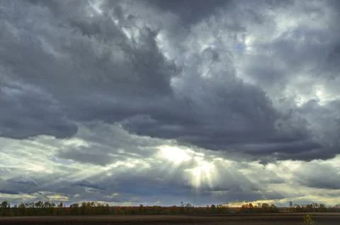 Cloudy sky with thick dense clouds that tightened the whole sky and thin rays Foto stock
