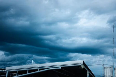 A cloudy sky with a white building in the background Stock Photos