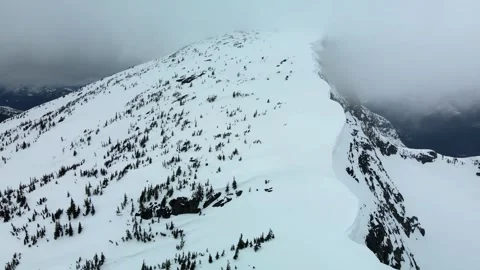 Cloudy snow covered mountain slope, drone shot Stock Footage 289576606