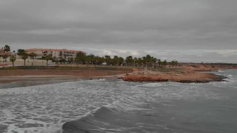 On a cloudy spring day, waves roll to the beach. Stock Footage 135350664