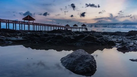 Cloudy Sunrise with jetty as a background and reflection Stockbeeldmateriaal 77200140