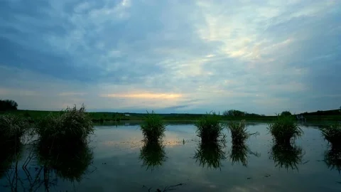 Cloudy sunrise over small pond during summer day. Stock Footage 130559184