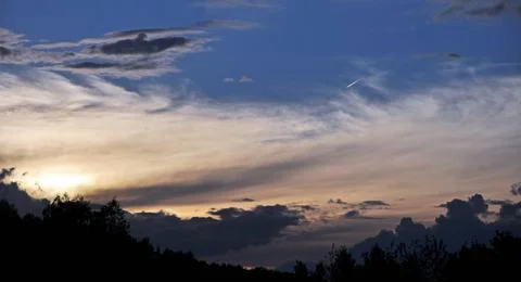 Cloudy sunset, clouds completely cover the solar disk. The sun sets in clouds Stock Photos