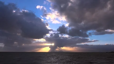 Cloudy sunset glows above calm open sea with blue orange sky and a horizon line Stock Footage 339339520