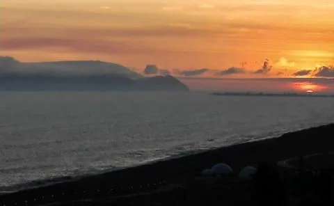 Cloudy sunset with island. Stock Photos
