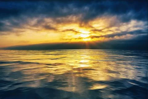 Cloudy sunset or sunrise reflected on smooth water Stock Photos