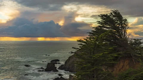 Cloudy sunset with orange light and rain in distance - timelapse Vídeos de archivo 220020098