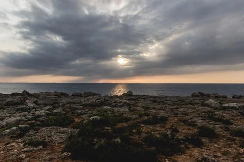 Cloudy sunset over cliff edge Stock Photos