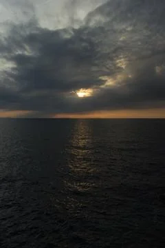Cloudy sunset over the dark sea Stock Photos