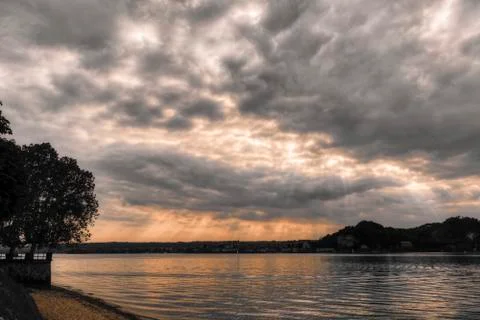 Cloudy sunset over the lake Stock Photos