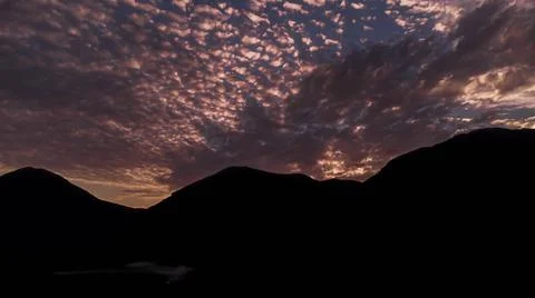 Cloudy sunset over mountains at winter Stockfoto's