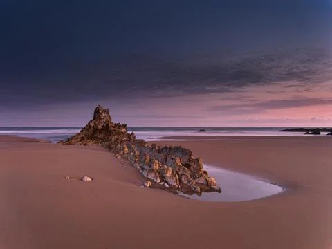 Cloudy sunset over a rugged Atlantic beach - A long-exposure shot of a dram.. Stock Photos