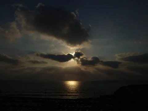 Cloudy sunset over a sandy beach ocean Foto stock