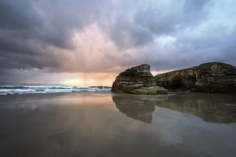 Cloudy Sunset Reflected in the Wet Sand of a Beach Stock Photos