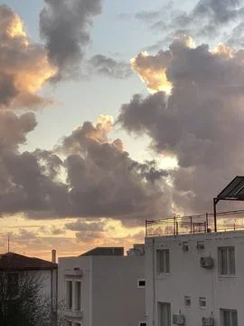 Cloudy sunset sky with soft pink and orange hues over building, perfect for.. Fotos Stock