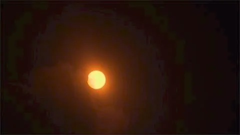 Cloudy View of the End of the Eclipse. Stock Photos