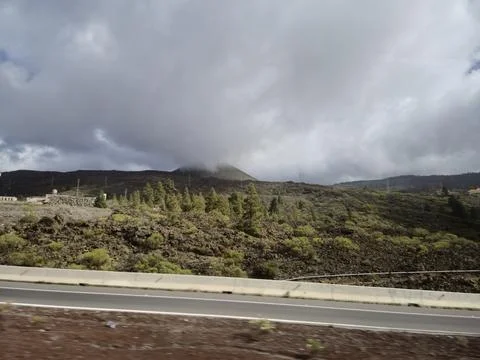 Cloudy volcanic landscape beside an empty road Stock Photos