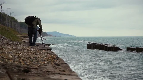 Cloudy windy cold day near the Black Sea, the photographer collects the equipmen Stock Footage 114627454