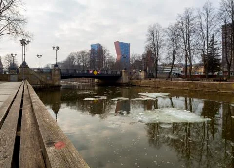 Cloudy winter day on a river with floating ice floes overlooking high-rise bu Stock Photos