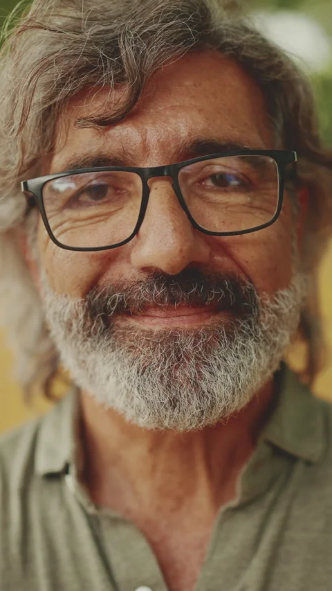 Clouse-up, friendly middle-aged man with gray hair and beard wearing casual Stockbeeldmateriaal 227022713