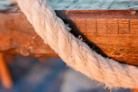Clouse up view over rope going around wooden beam Stock Photos