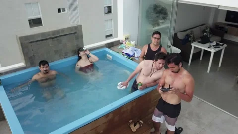 Clouseup of aerial drone view of several friends in the pool on the terrace of a Stock Footage 195968314