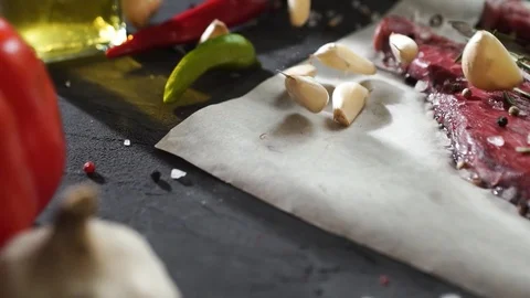 Cloves of garlic fall on the table. cheese steak, pepper, olive oil lie on a Stock Footage 115829114
