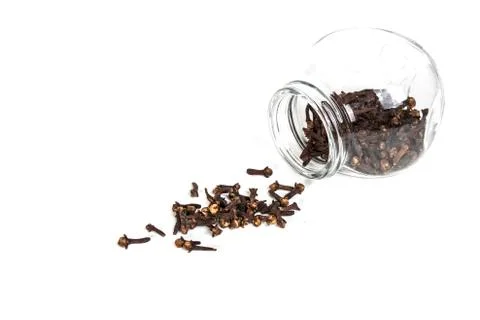 Cloves scattered from the jar on a white background Stock Photos
