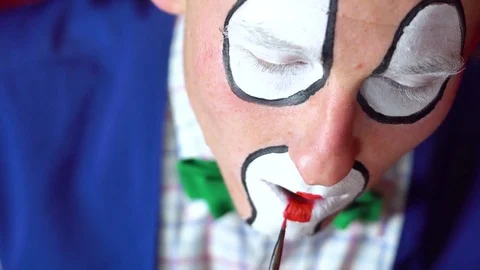 The clown draws a red lips Stock Footage 84646062