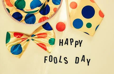 A clown hat, two ties, and a red nose ball with the words "Happy Full Day" Stock Photos