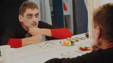 Clown mime looking at herself in the mirror and makes faces Stock-Footage 67897129