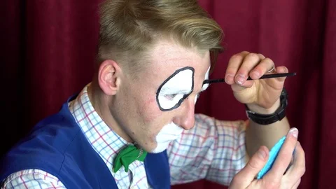 Clown puts makeup on eyebrows Stock Footage 84642208