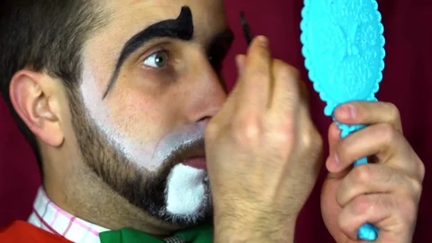 Clown puts a makeup on her eyebrows Stock-Footage 84642034