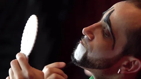 Clown puts a makeup on her face Stock-Footage 84642176