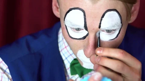 Clown puts a makeup on her face Stock Footage 84642242