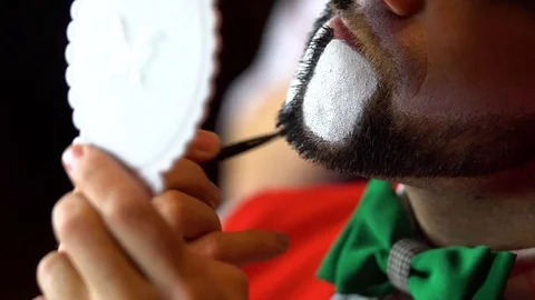 Clown puts makeup on his beard Stock Footage 84642163