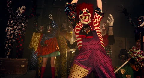The clown in the red wig standing with a chainsaw. 库存影片 67871522