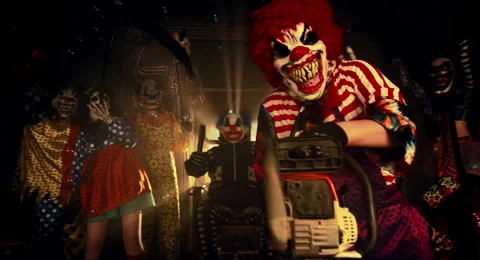 The clown in the red wig standing with a chainsaw. Stock Footage 67871625