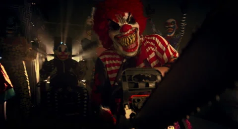 The clown in the red wig standing with a chainsaw. 스톡 동영상 67871730