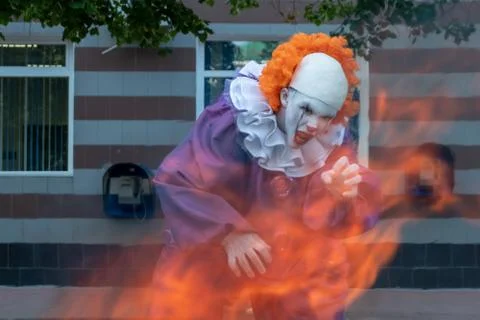 Clown with sharp teeth on fire on a urban background with payphones .. Hallow Stock Photos