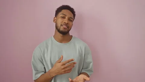 Clueless african american guy wearing a t-shirt, shrugging on an isolated p.. Stock Footage 278528079