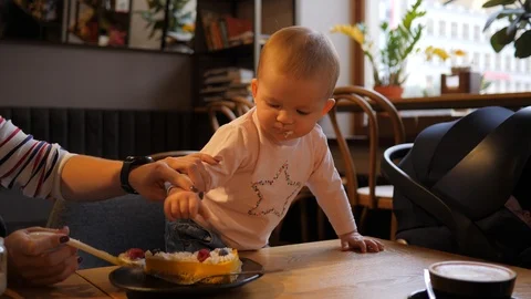 Clumsy baby try to put raspberry in a mouth suddenly drop in on a table and do Stock Footage 116598792