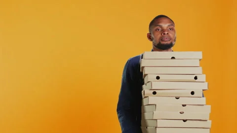 Clumsy deliveryman dropping a huge stack of pizza boxes in studio Video stock 275560589